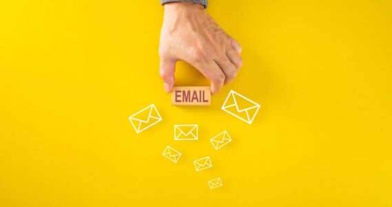 Businessman placing wooden blocks with EMAIL word on yellow back